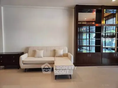 Modern living room with elegant sofa and stylish wooden shelving unit.