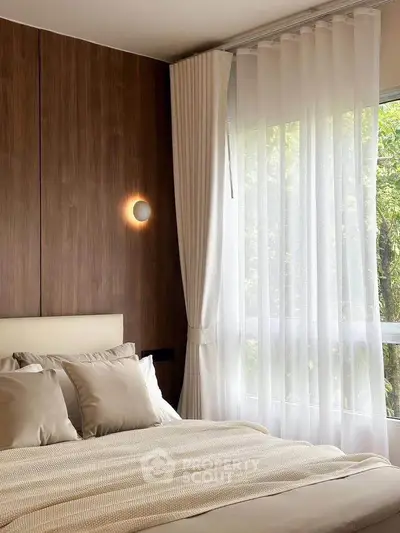 Elegant bedroom with wooden accent wall and large window with sheer curtains.