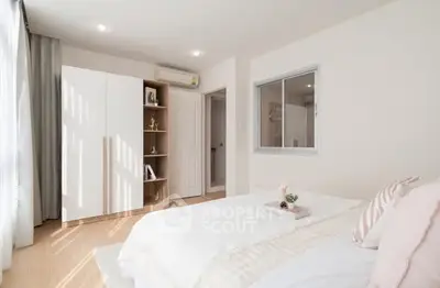 Bright and cozy bedroom with modern decor and ample natural light.