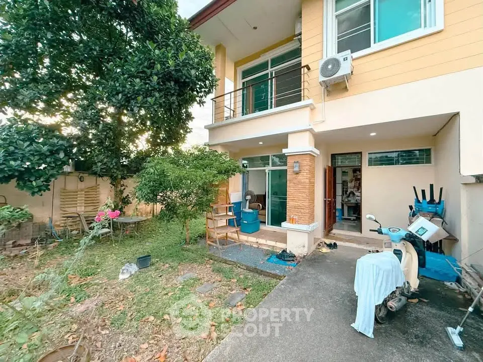 Charming two-story home with lush garden and spacious patio, perfect for outdoor relaxation and entertaining.
