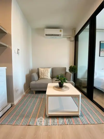 Cozy living room with modern decor and air conditioning, featuring a stylish sofa and coffee table.