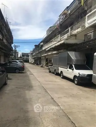 Urban street view with parked vehicles and residential buildings