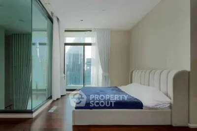 Modern bedroom with large glass windows and city view, featuring a stylish bed and elegant curtains.
