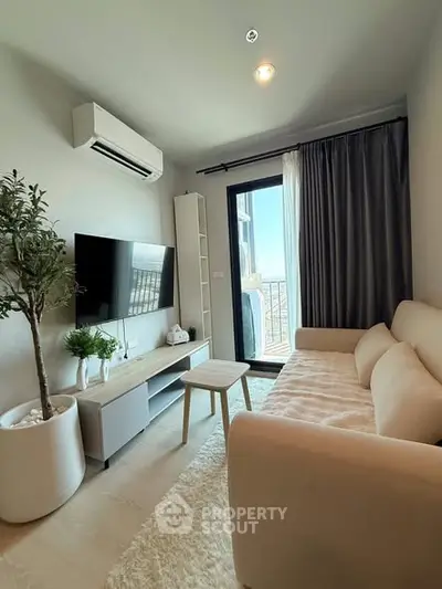 Modern living room with balcony view, stylish furniture, and natural light.