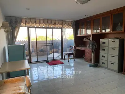 Spacious room with large windows and garden view, ideal for home office or study area.