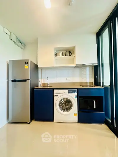 Modern kitchen with sleek appliances and stylish cabinetry in a contemporary apartment.