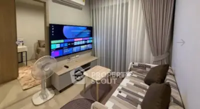 Modern living room with stylish decor and large TV, perfect for relaxation.