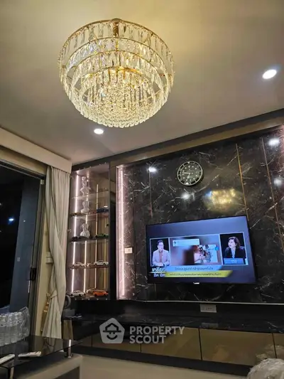 Luxurious living room with elegant chandelier and modern TV setup