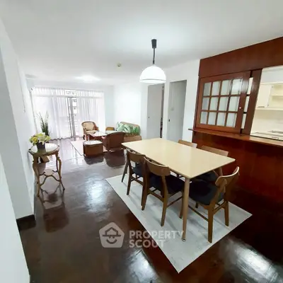 Spacious open-plan living and dining area with elegant wooden flooring and modern furnishings.