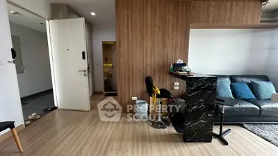 Modern living room with stylish decor and open layout, featuring a cozy sofa and sleek bar counter.