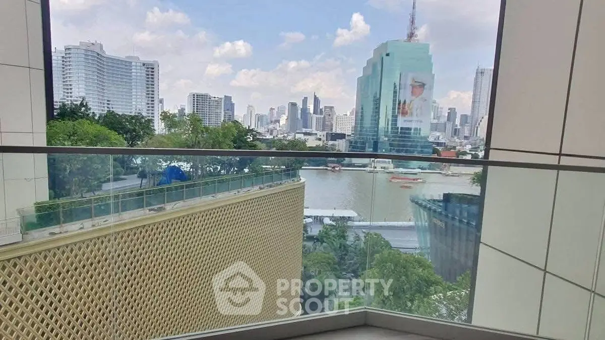 Stunning cityscape view from a modern balcony with glass railing overlooking river.
