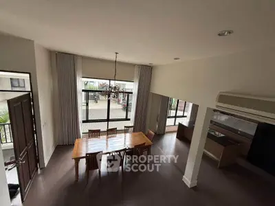 Spacious dining area with large windows and elegant wooden table in modern home