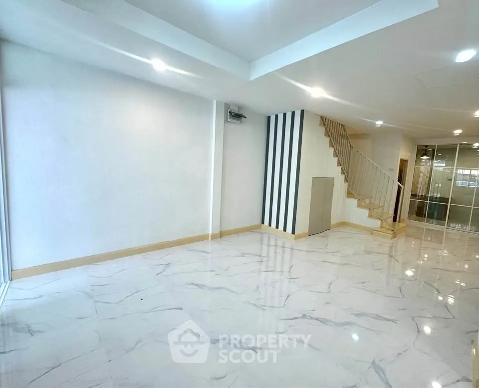 Spacious modern living room with marble flooring and staircase