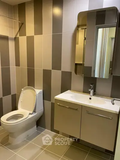 Modern bathroom with sleek design and contemporary fixtures, featuring a stylish vanity and tiled walls.