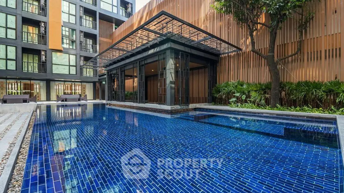 Luxurious modern apartment complex with stunning outdoor pool and lush greenery.