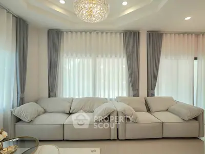 Luxurious living room with elegant gray sofas and a stunning chandelier, perfect for modern comfort and style.