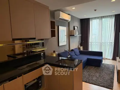 Modern open-layout kitchen and living room with sleek design and natural light.