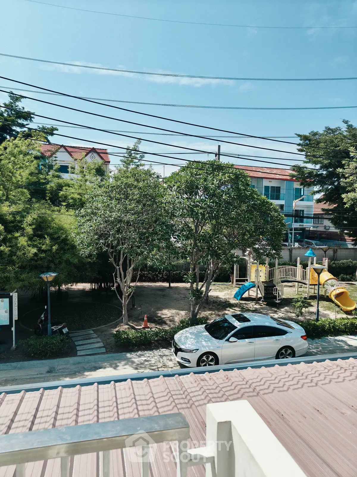 Charming residential view with lush greenery and a playground, perfect for family living.