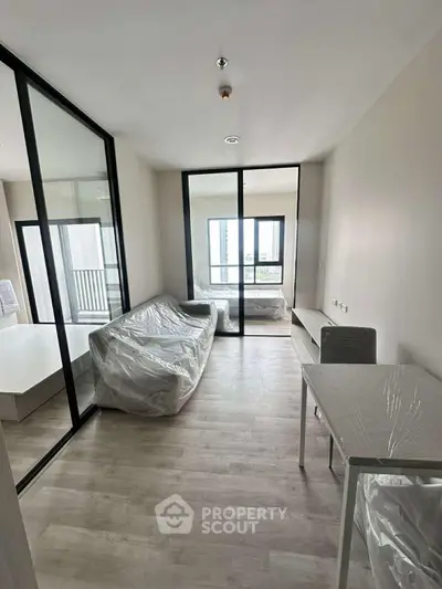Modern living room with floor-to-ceiling windows and sleek furniture in a stylish apartment.
