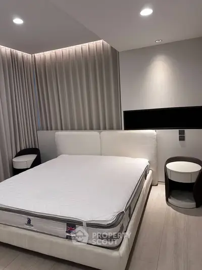 Modern bedroom with elegant lighting and stylish furniture, featuring a comfortable bed and sleek side tables.