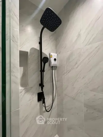 Modern bathroom shower with sleek black fixtures and marble tiles