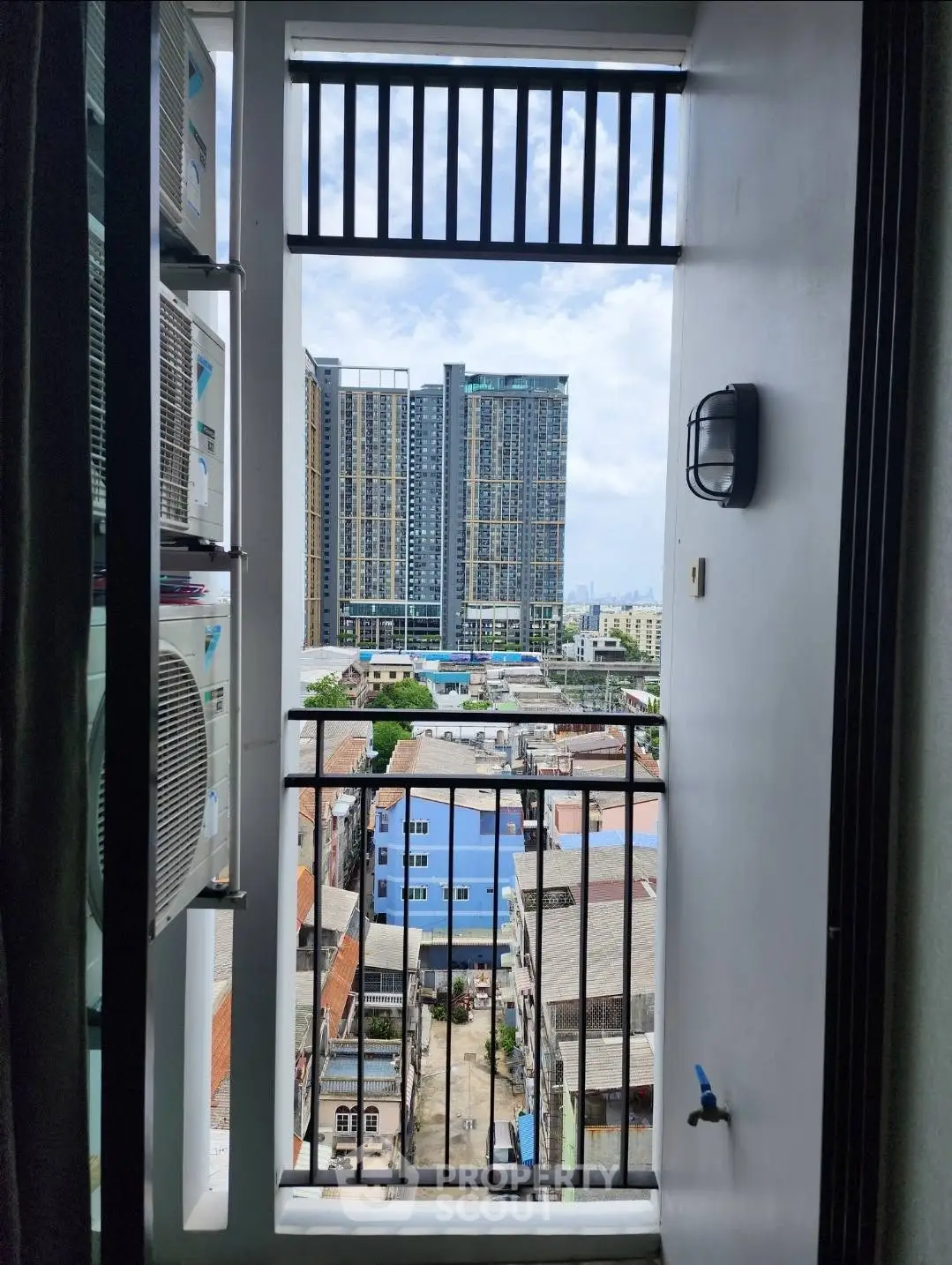 Stunning urban view from a high-rise balcony overlooking cityscape and modern buildings.