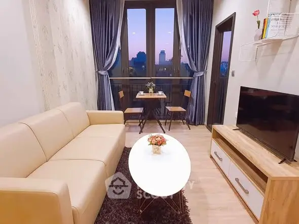 Charming living room with cozy seating and city view balcony at sunset.