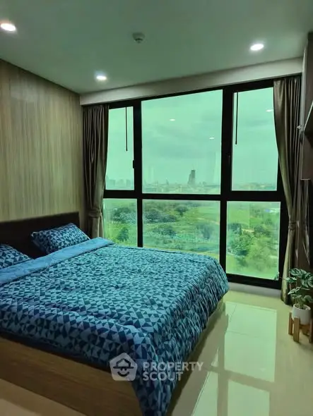 Modern bedroom with large window offering stunning city view, featuring stylish decor and cozy bedding.