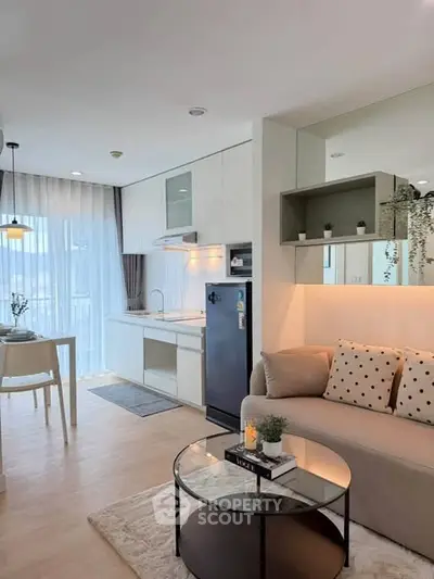 Modern open-layout living room and kitchen with stylish decor and natural light.