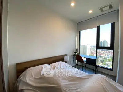 Modern bedroom with city view and natural light, featuring a cozy bed and stylish decor.