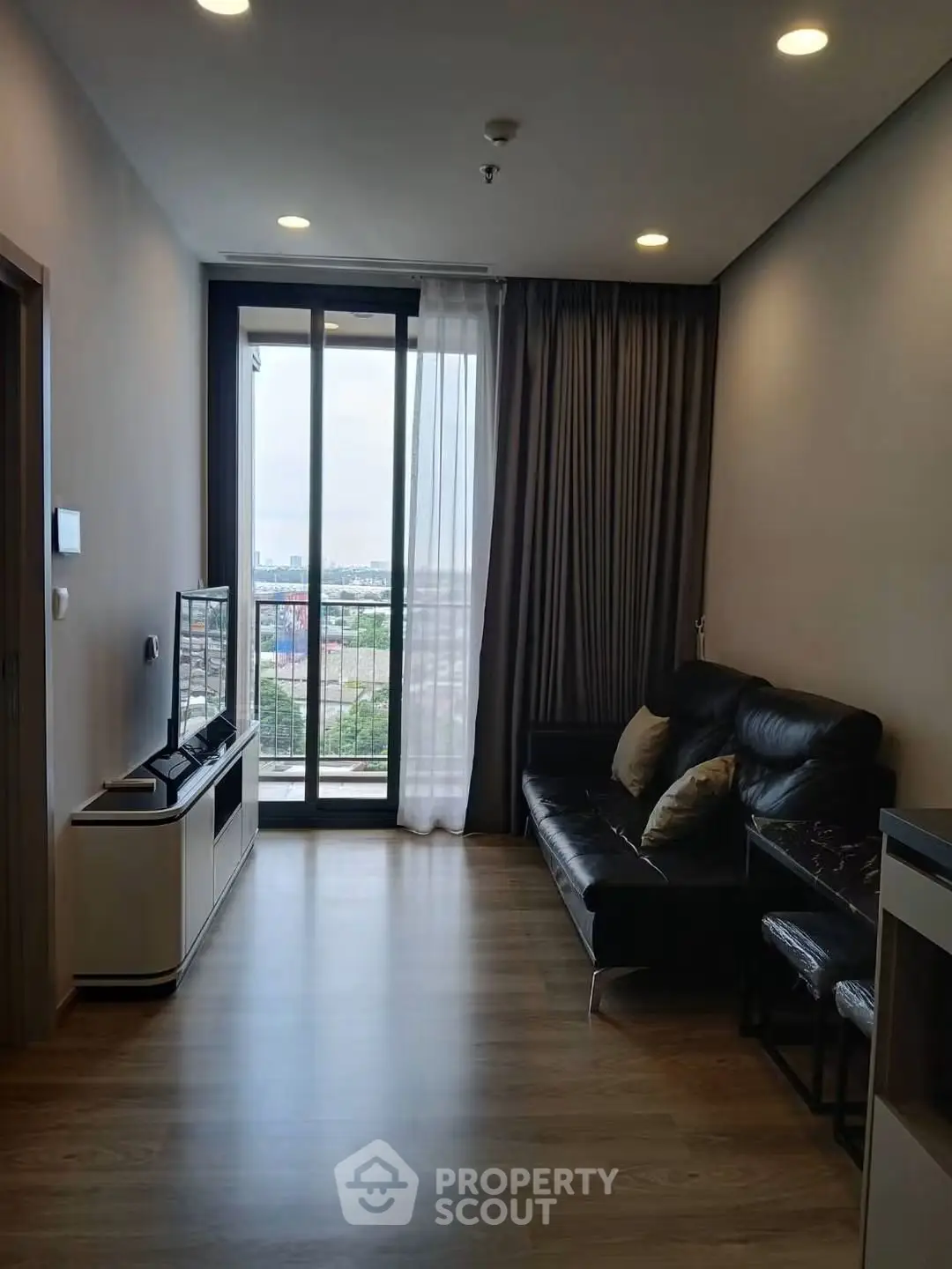 Modern living room with sleek design and large window offering city view