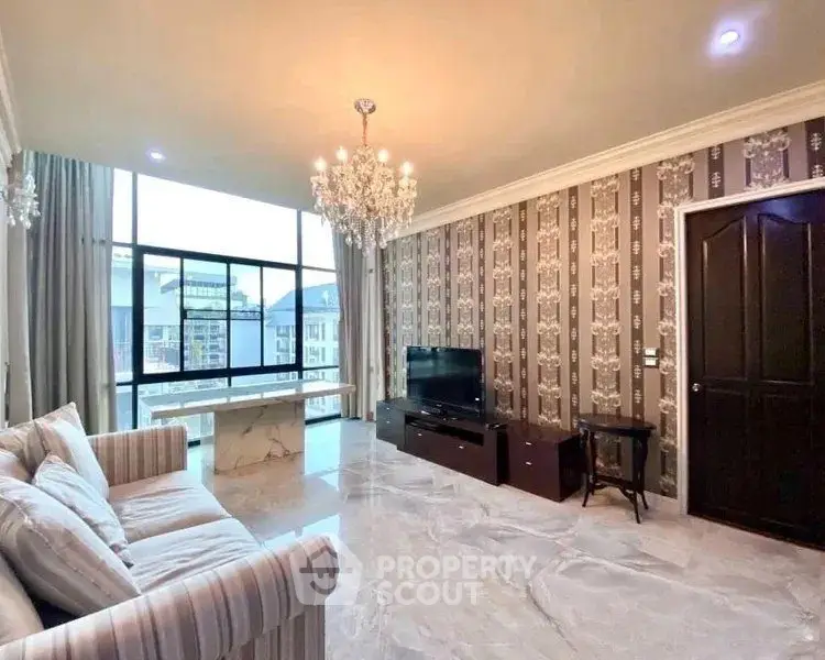 Luxurious living room with elegant chandelier and large windows offering stunning views.