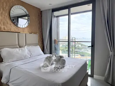 Luxurious bedroom with balcony offering stunning city and ocean views