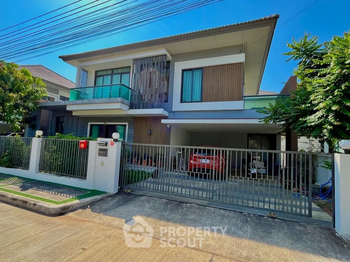 Modern two-story house with balcony and garage in a suburban neighborhood.