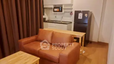Cozy living room with brown sofa and compact kitchen in modern apartment