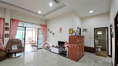 Spacious living room with modern decor and access to a bright balcony.
