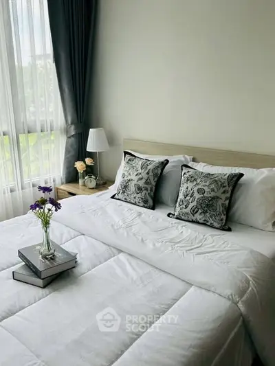 Cozy bedroom with elegant decor and natural light, featuring plush bedding and stylish accents.