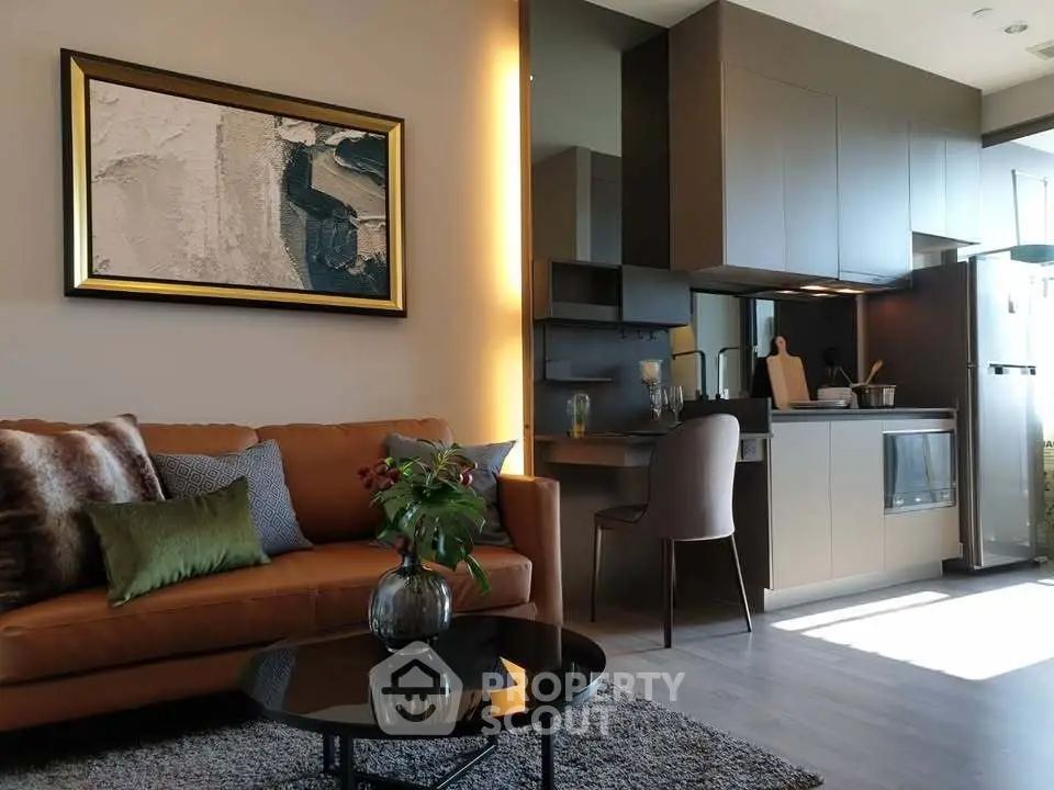 Modern living room with stylish kitchen, featuring sleek cabinetry and cozy seating area.