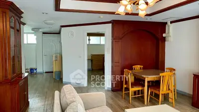 Spacious living room with elegant wooden furniture and cozy dining area.