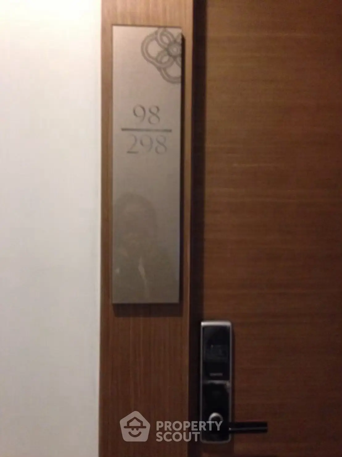 Modern apartment door with electronic lock and room number plaque