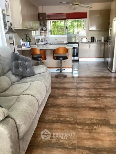 Spacious open-layout kitchen with modern appliances and cozy living area, perfect for family gatherings.