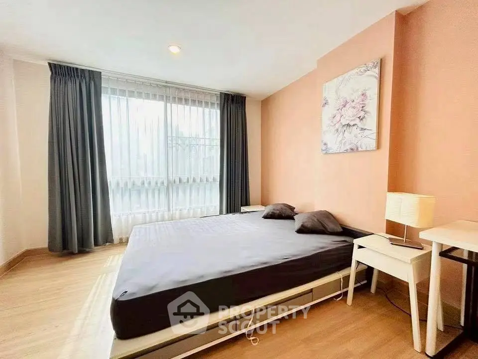 Spacious bedroom with large window and modern decor in a stylish apartment.