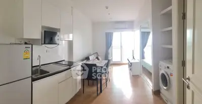 Modern apartment interior with kitchen and living area, featuring sleek appliances and natural light.