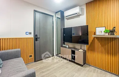 Modern living room with stylish decor and air conditioning, featuring a sleek TV setup and cozy seating.