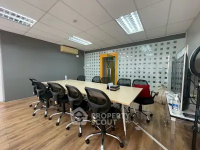 Modern office meeting room with large table and ergonomic chairs, ideal for business gatherings.