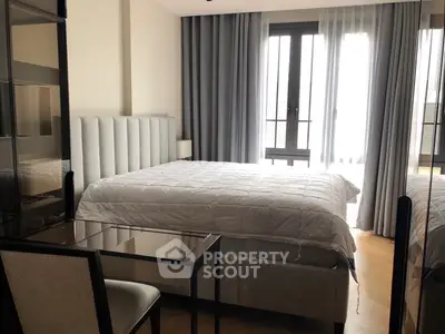 Modern bedroom with stylish decor and large windows offering natural light