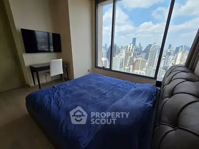 Luxurious bedroom with stunning city skyline view and modern furnishings.