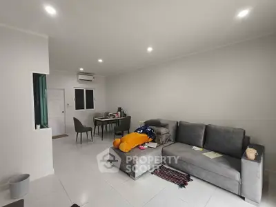 Spacious modern living room with gray sofa and dining area, perfect for relaxation and entertaining.