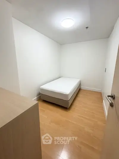 Cozy minimalist bedroom with wooden flooring and simple decor