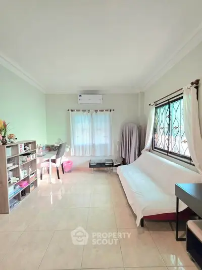 Spacious living room with natural light, tiled floors, and modern furnishings, perfect for relaxation and entertaining.